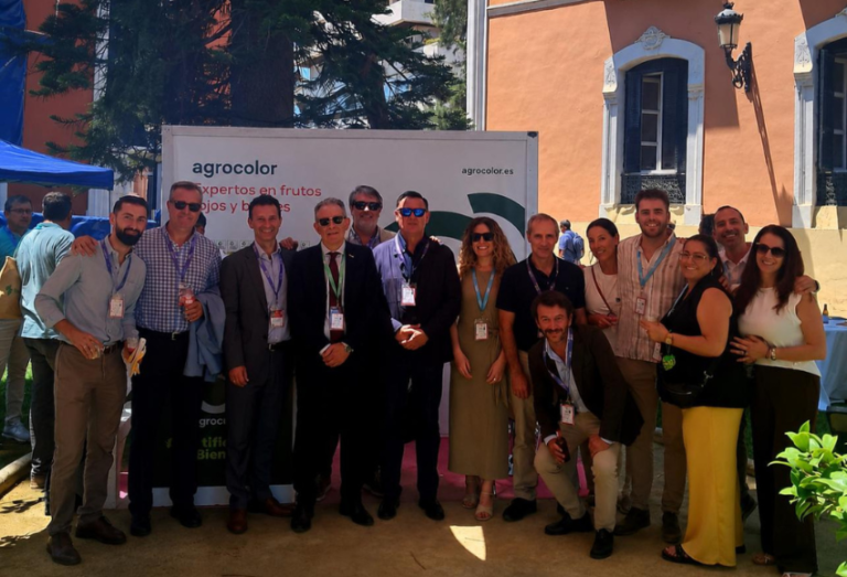 Grupo de profesionales en el congreso de frutos rojos con banner de Agrocolor