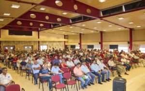 Reunión de agricultores en un salón, promoviendo el cooperativismo agrícola.