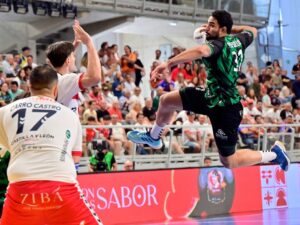 Jugador lanzando el balón en la final de balonmano con público animado