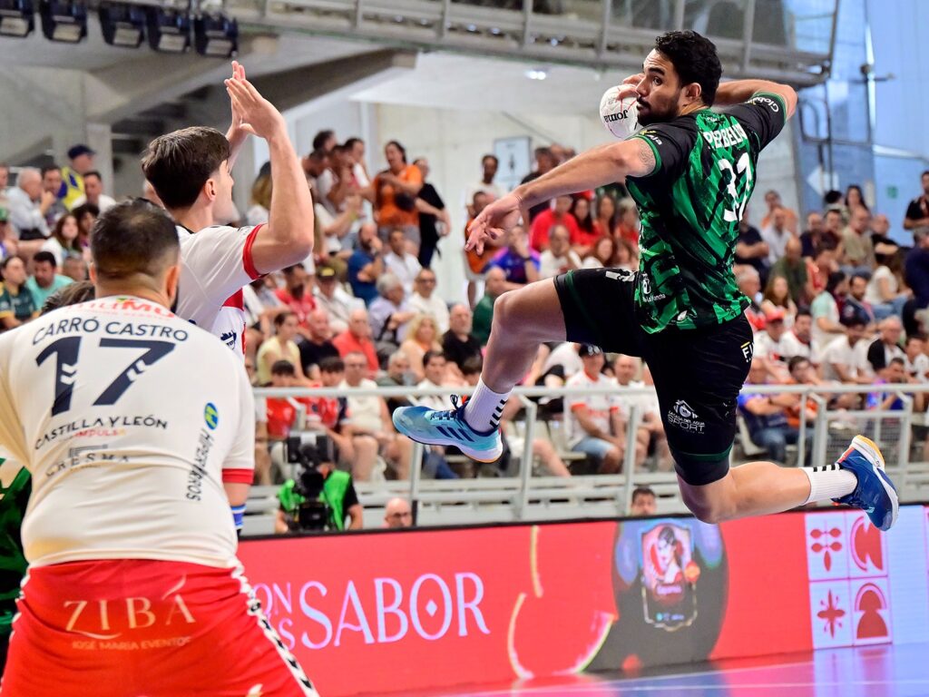 Jugador lanzando el balón en la final de balonmano con público animado