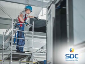 Técnico revisando instalaciones frigoríficas en altura con equipo de seguridad