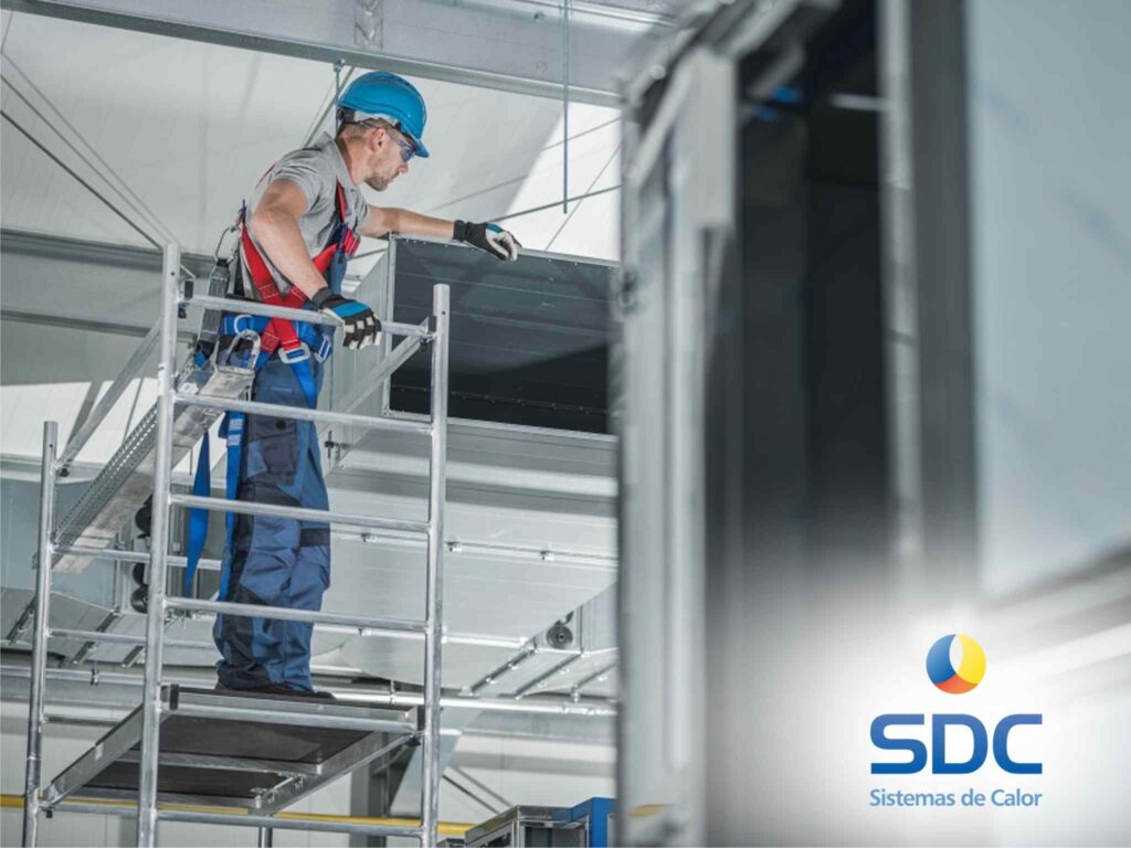 Técnico revisando instalaciones frigoríficas en altura con equipo de seguridad